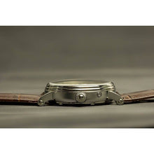 Load image into Gallery viewer, The Heritage timepiece is a grand manifest in the refinement and aesthetics. With inventive and meticulous architecture of its dual balance wheel, a sleek profile of the hands, timekeeping is optimized to the highest amplitude. Encased with a refined silver titanium dial and a high quality 316L stainless steel casing lie the the two hearts of this exclusive timepiece that is powered by a 26 jewel automatic movement with a 60-hour power reserve. Made for the dedicated watch lover with a genuine taste for fin