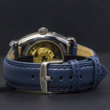 Load image into Gallery viewer, Le Cadre is a venture into fine craftsmanship and an elevation of contemporary design. Exuding an air of fine taste and class with a flawless aesthetic face, the silver coated stainless steel rectangular structure embodies sheer exclusivity. Features include a flying Tourbillon within our signature Matt Arend skeleton calibre, 21 jewel automatic movement with a 60-hour power reserve, day/night, date, hour, minute, second, dual time zone and power reserve of moment indicator functions.