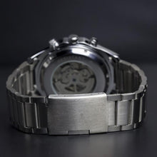 Load image into Gallery viewer, Elements with its raw metallic skeleton design is a magnetic timepiece for the modern gentleman. Equipped with stainless steel case and strap and a black and silver metallic face to give this timepiece its solid masculine character. Features include hour, minute, second, date and month indicators and an automatic mechanical chronometer with a 48-hour power reserve. 
