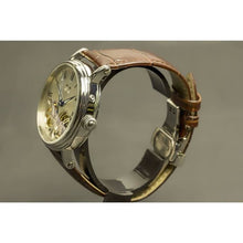 Load image into Gallery viewer, The Heritage timepiece is a grand manifest in the refinement and aesthetics. With inventive and meticulous architecture of its dual balance wheel, a sleek profile of the hands, timekeeping is optimized to the highest amplitude. Encased with a refined silver titanium dial and a high quality 316L stainless steel casing lie the the two hearts of this exclusive timepiece that is powered by a 26 jewel automatic movement with a 60-hour power reserve. Made for the dedicated watch lover with a genuine taste for fin
